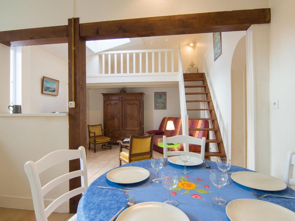 a dining room with a table and chairs and a staircase at Holiday Home Doumer by Interhome in Royan