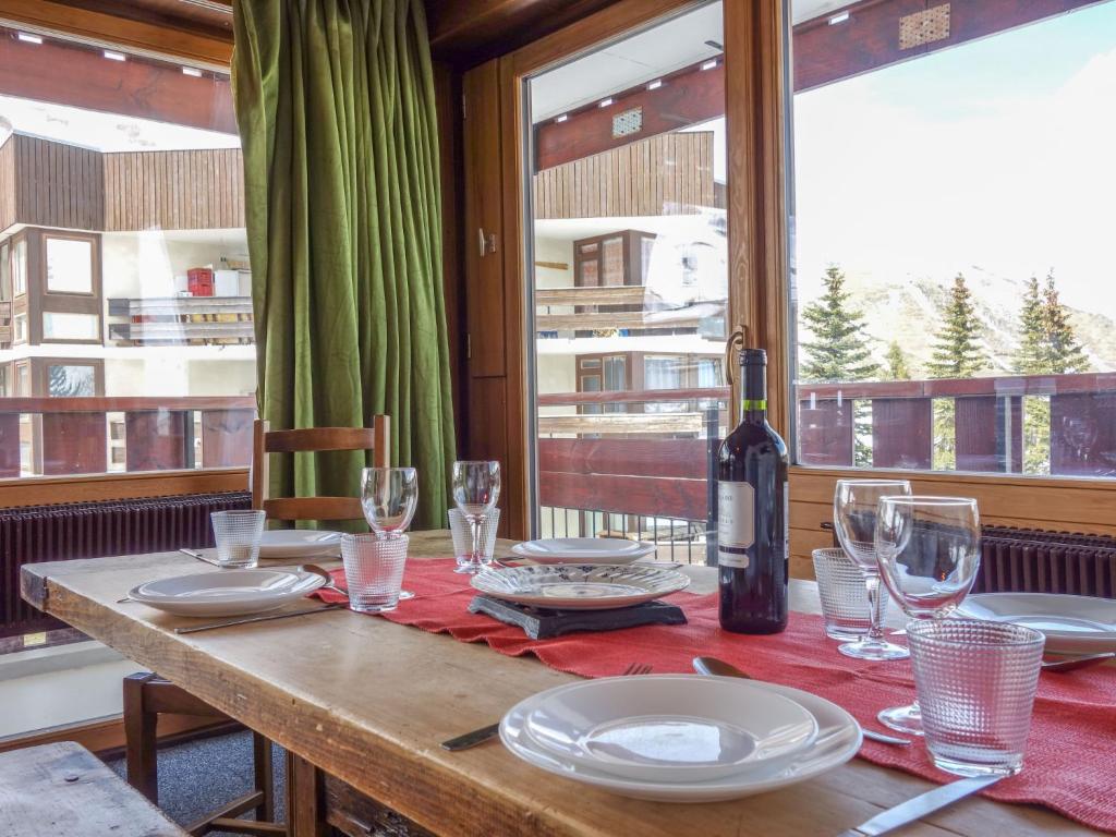 una mesa con platos y copas y una botella de vino en Apartment La Grande Casse-2 by Interhome en Tignes