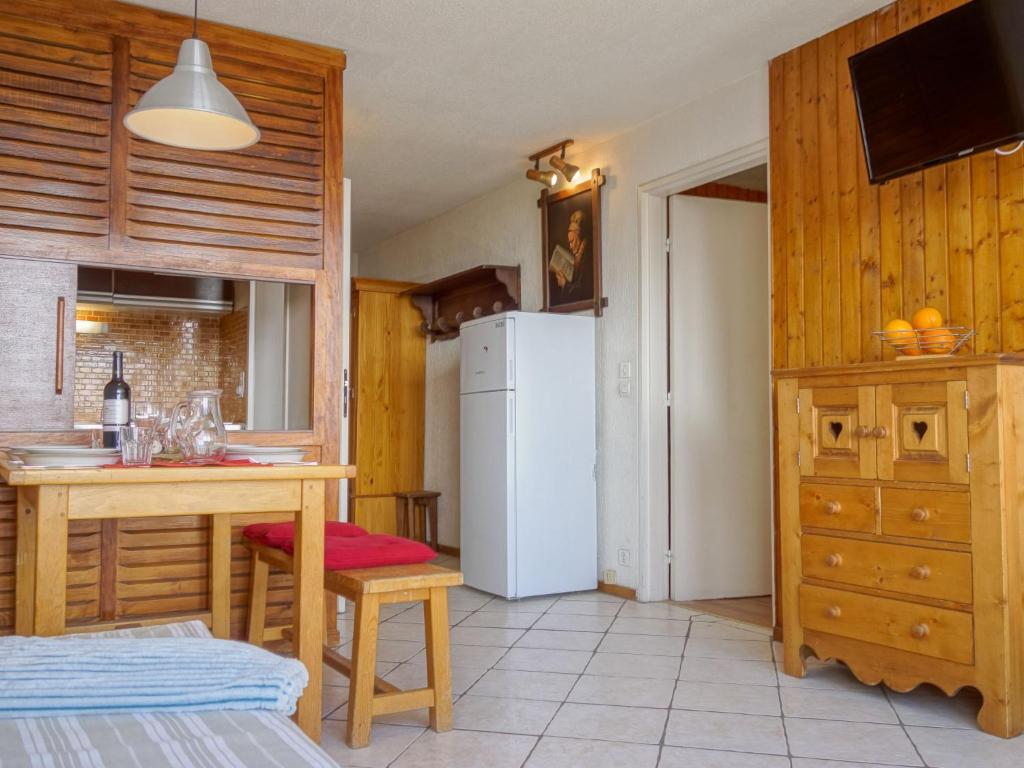 une cuisine avec une table et un réfrigérateur blanc dans l'établissement Apartment Platières-4 by Interhome, à Tignes