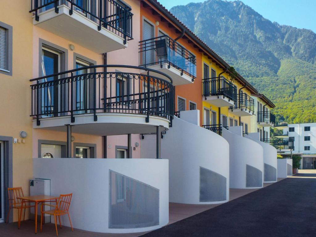 ein Gebäude mit Balkon, Tisch und Stühlen in der Unterkunft Apartment Vasco de Gama B8-R by Interhome in Bouveret