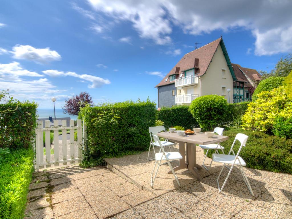 un patio con mesa y sillas frente a una casa en Apartment Le Cap Bleu by Interhome, en Blonville-sur-Mer