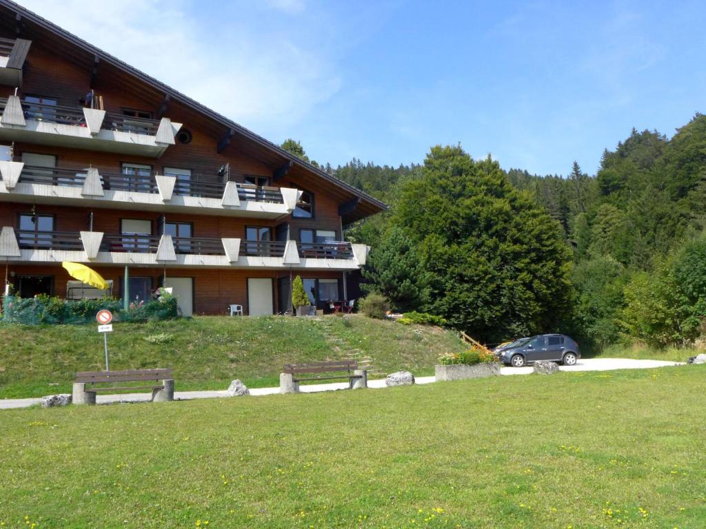 un grand bâtiment avec bancs devant lui dans l'établissement Apartment Eridan by Interhome, à Les Rasses