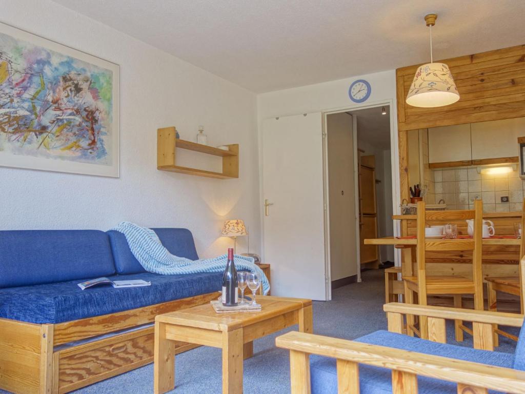 uma sala de estar com um sofá azul e uma mesa em Apartment Les Tommeuses - Val Claret-19 by Interhome em Tignes