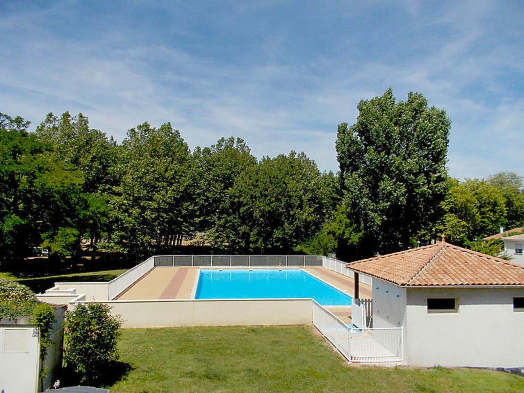 a swimming pool in a yard next to a house at Apartment Terrasses de Pontaillac by Interhome in Pontaillac