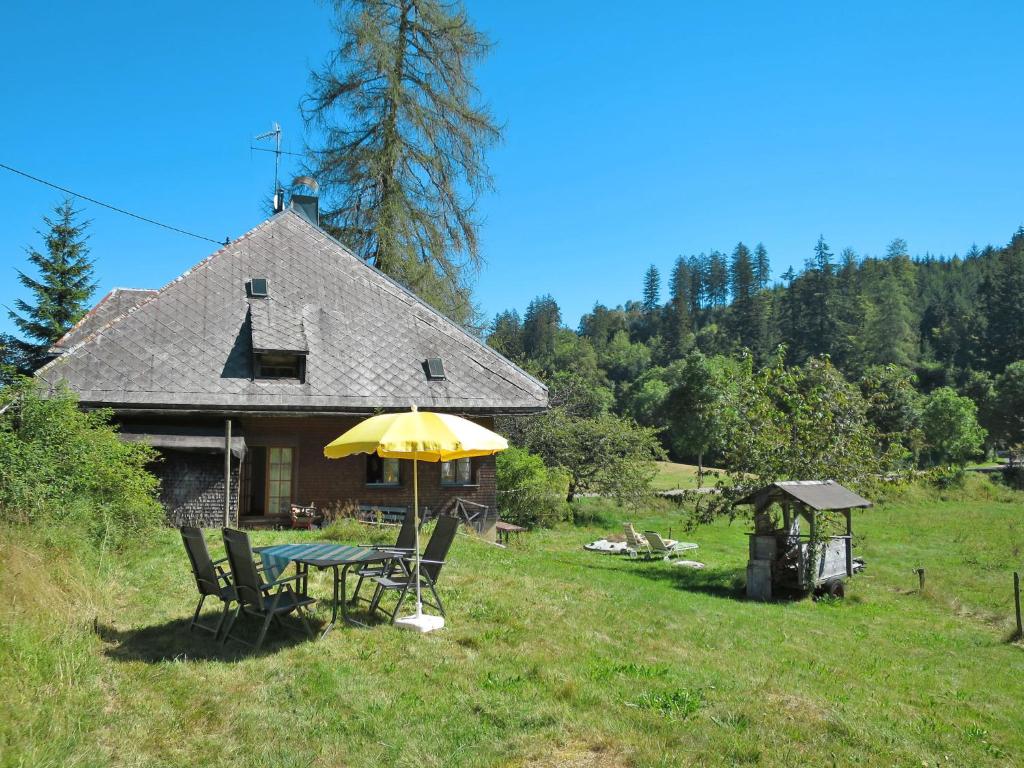 un tavolo con un ombrello giallo di fronte a una casa di Holiday Home Bistenhof by Interhome a Hinterzarten