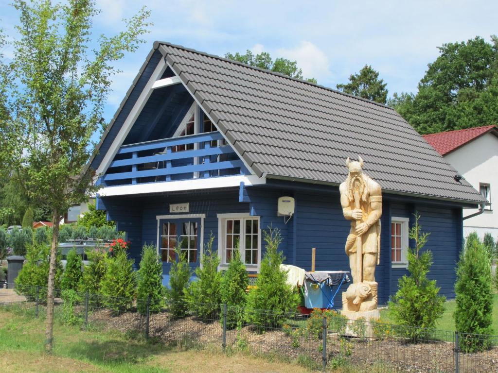 a blue house with a statue in front of it at Holiday Home Zum Stolpseefischer by Interhome in Himmelpfort