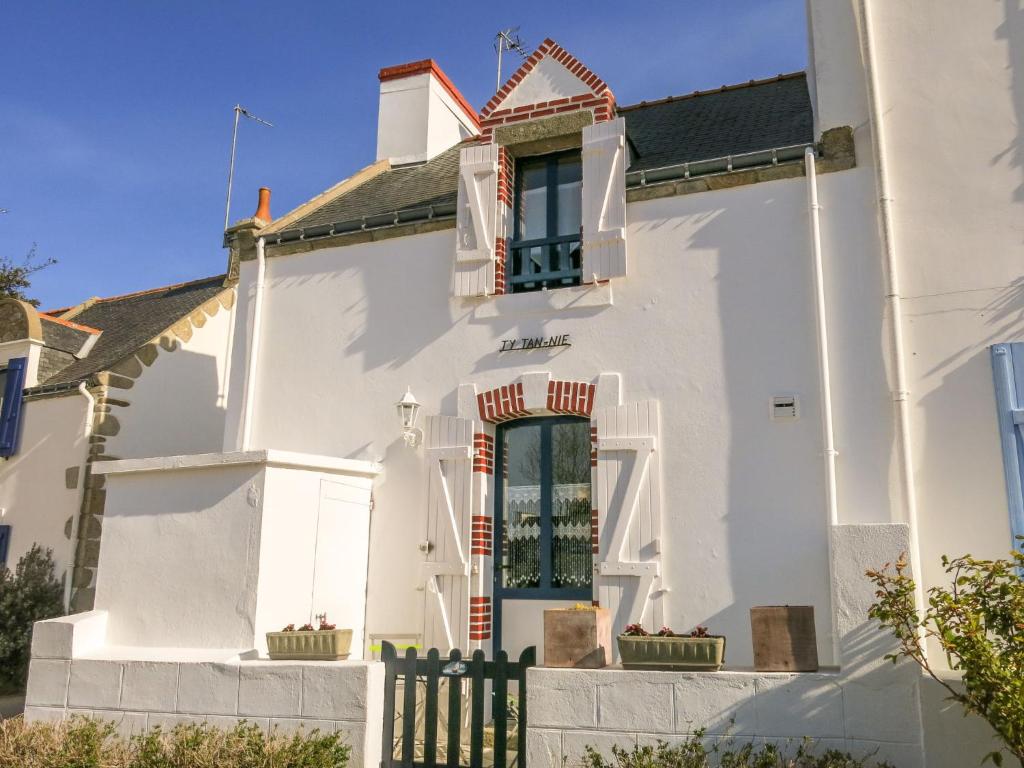 uma casa branca com uma porta e uma janela em Holiday Home Ty Tan-Nie - QUB301 by Interhome em Quiberon