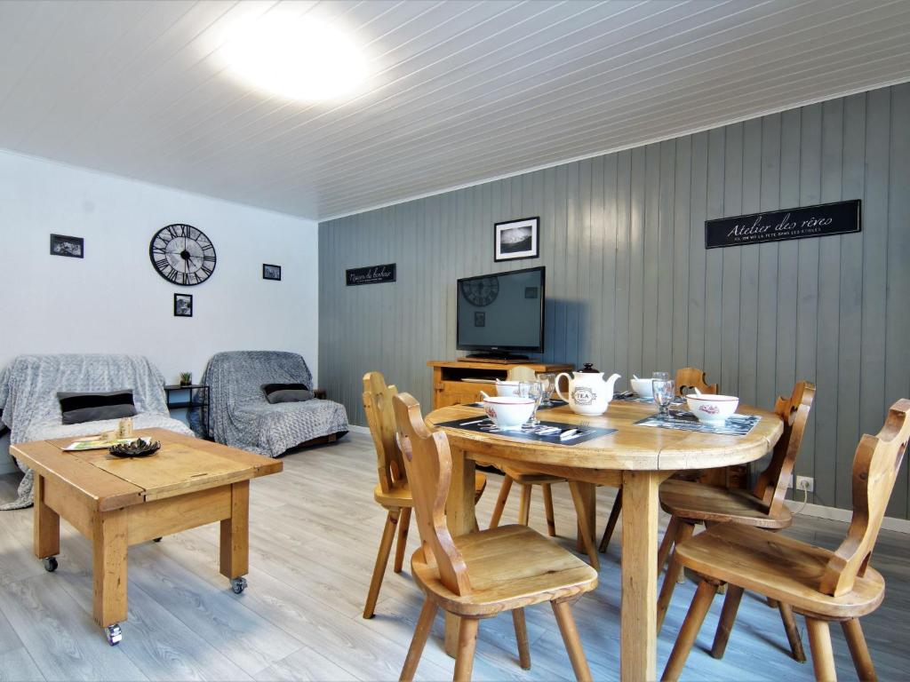 comedor con mesa, sillas y TV en Apartment L'Outa by Interhome, en Chamonix-Mont-Blanc