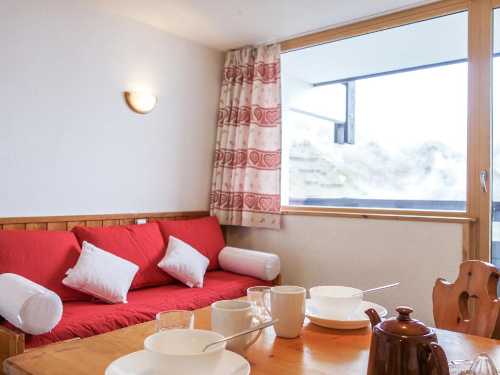 a living room with a red couch and a table at Apartment Home Club-1 by Interhome in Tignes