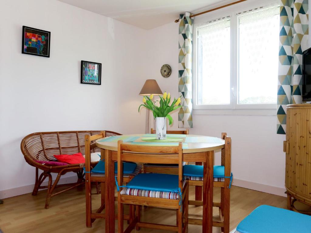 una sala da pranzo con tavolo, sedie e finestra di Apartment Ty Ménez - GLN105 by Interhome a Goulien