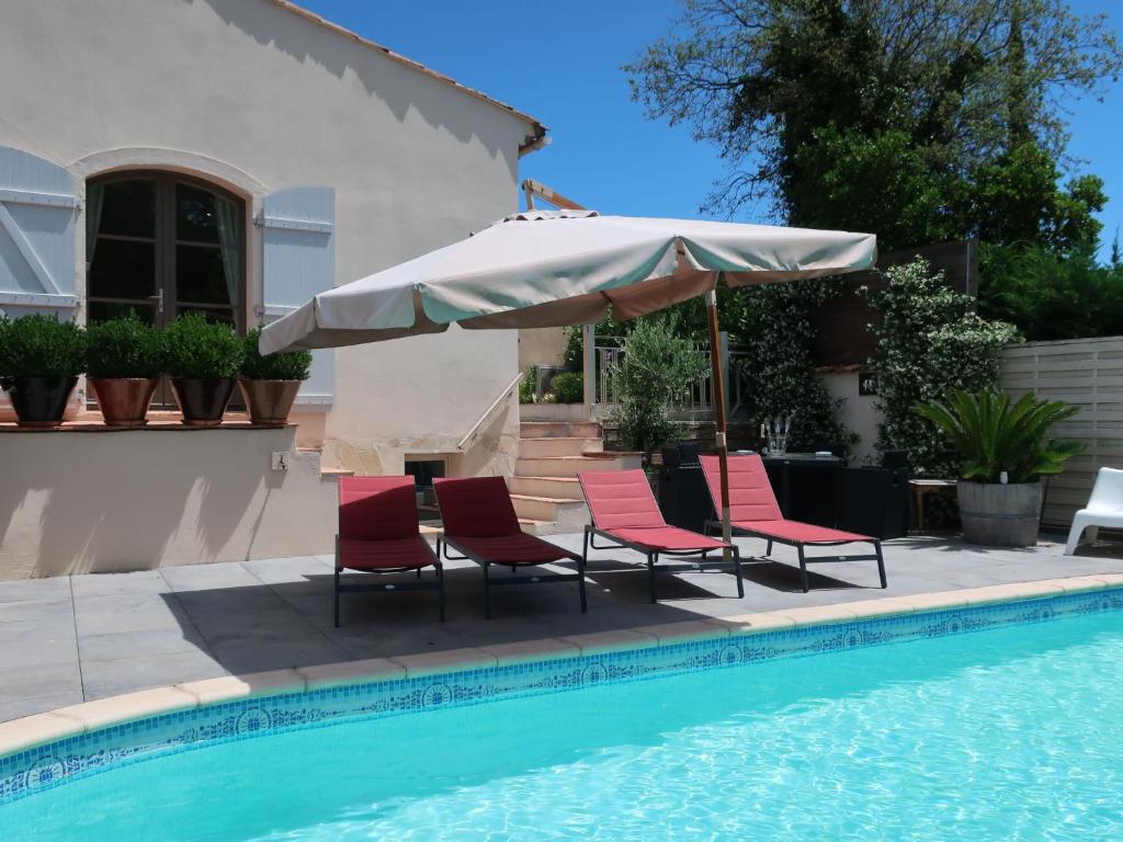 - un groupe de chaises et un parasol à côté de la piscine dans l'établissement Holiday Home La Chartreuse by Interhome, à La Môle
