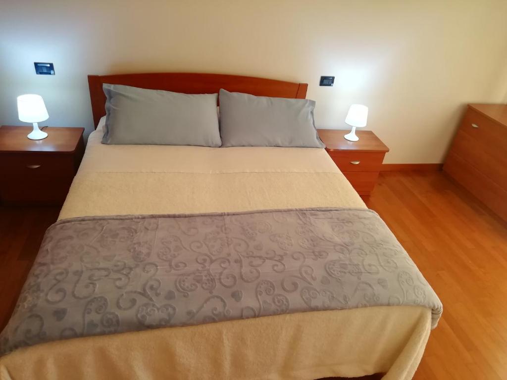 a bedroom with a large bed with two night stands at Holiday Apartment Venice Padua Agripolis in Legnaro