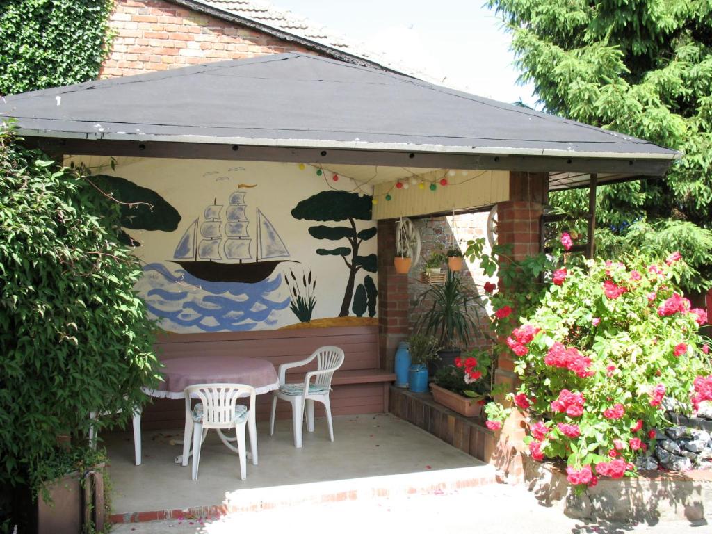 un patio con mesa, sillas y una pintura en Holiday Home Kaiser by Interhome, en Garz