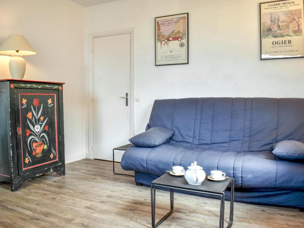 ein blaues Sofa im Wohnzimmer mit einem Tisch in der Unterkunft Apartment Castel Guermante by Interhome in Deauville