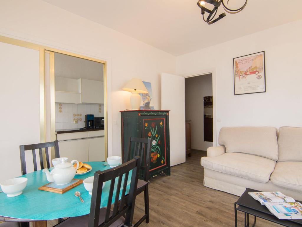 ein Wohnzimmer mit einem Tisch und einem Sofa in der Unterkunft Apartment Castel Guermante by Interhome in Deauville