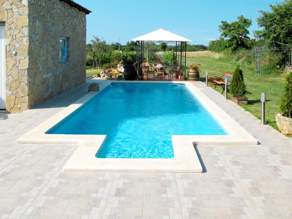 a swimming pool in front of a house at Holiday Home Pinezici - RCA151 by Interhome in Marčana