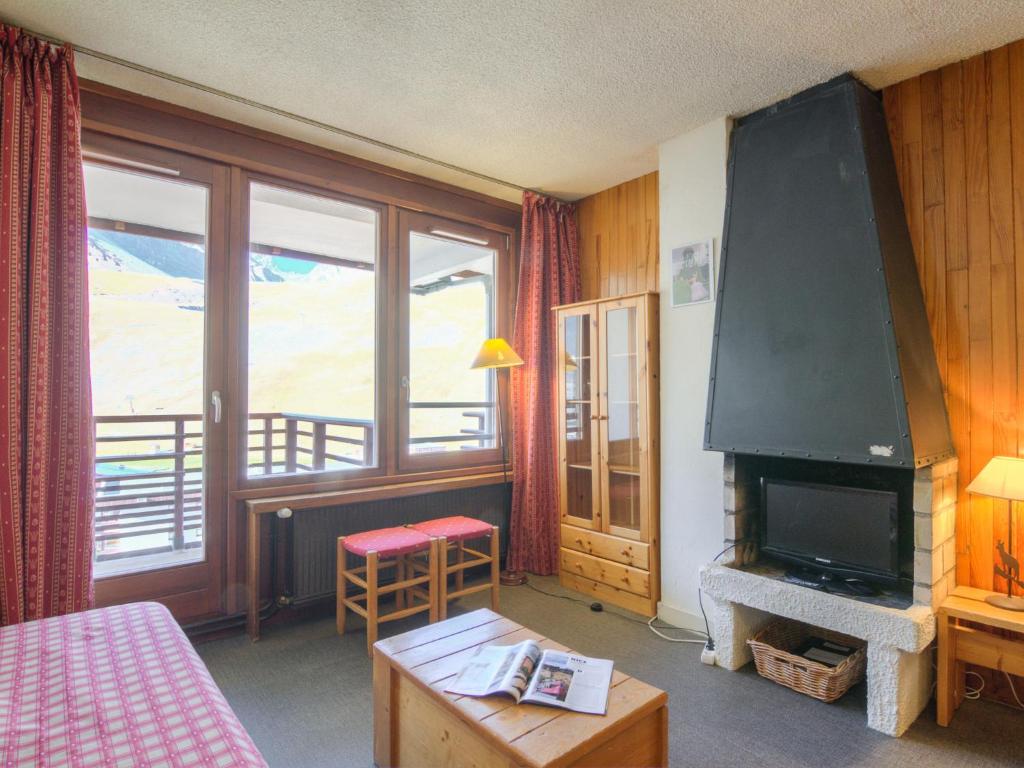 een kamer met een bed en een open haard met een tv bij Apartment Le Curling B-7 by Interhome in Tignes