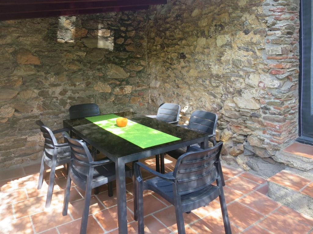 a black table with chairs and an orange on it at Holiday Home Oleander by Interhome in Tordères