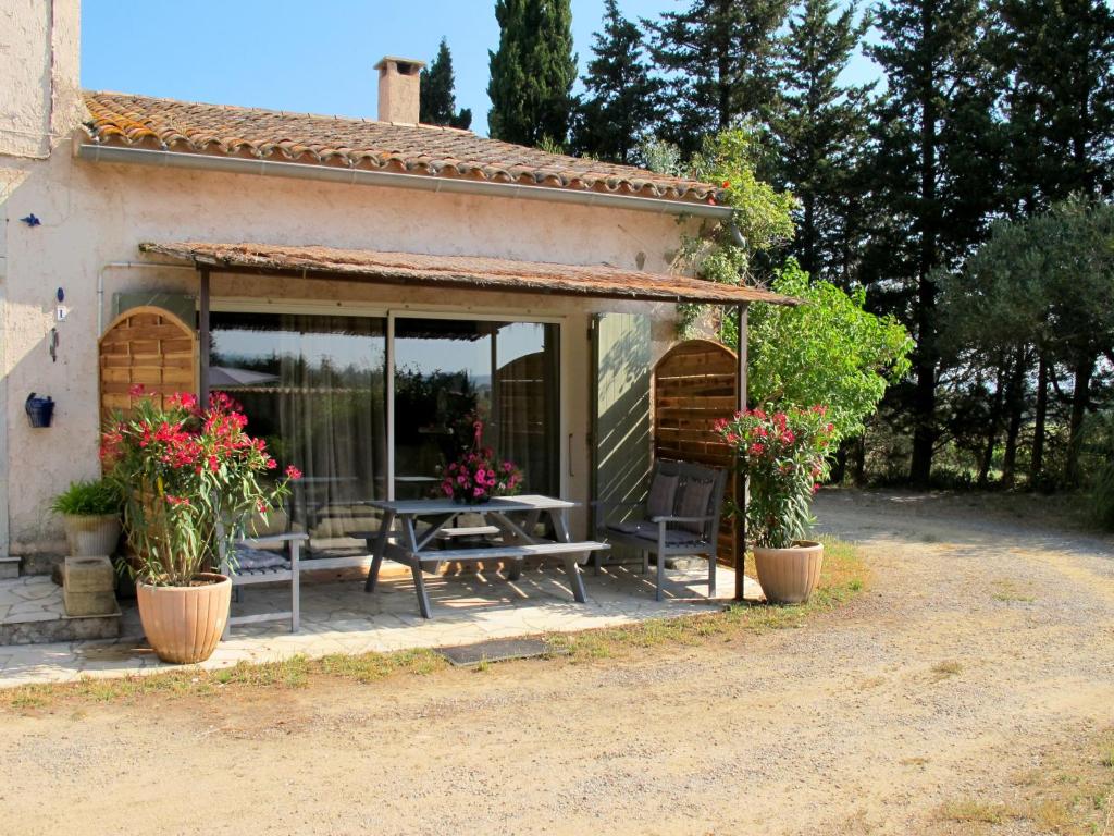 une terrasse d'une maison avec une table et des fleurs dans l'établissement Holiday Home Mas du Combaud-2 by Interhome, à Roquebrune-sur Argens