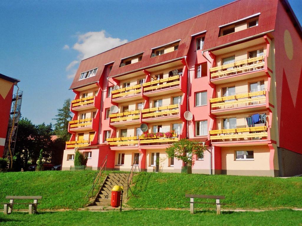 a large pink building with benches in front of it at Apartment Ewa by Interhome in Szklarska Poręba