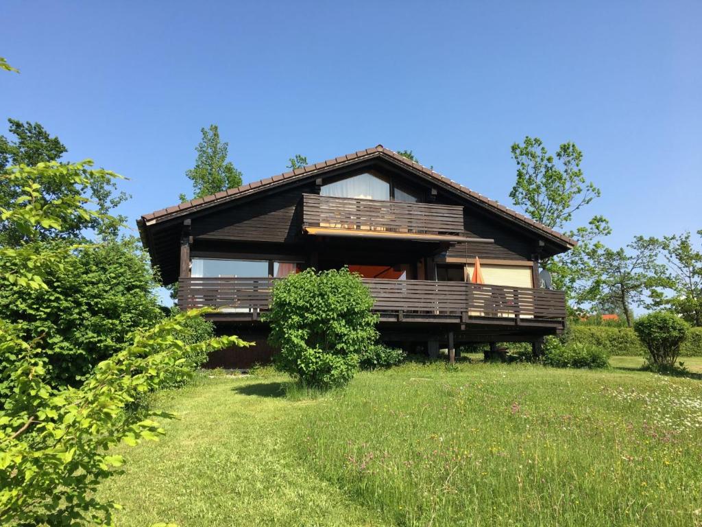 a large house with a porch on a grass field at Holiday Home Ferienpark Vorauf-3 by Interhome in Molberting