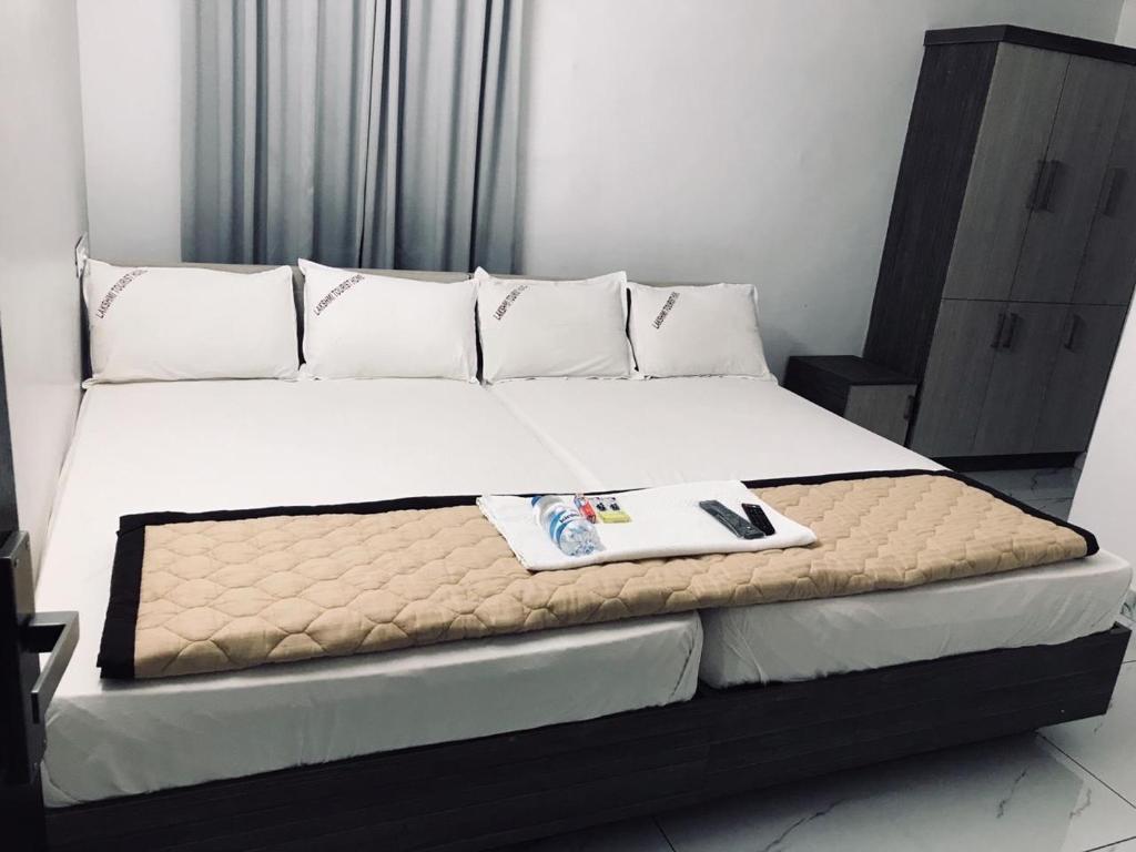 een bed in een slaapkamer met een bord erop bij LAKSHMI TOURIST HOME in Guruvāyūr