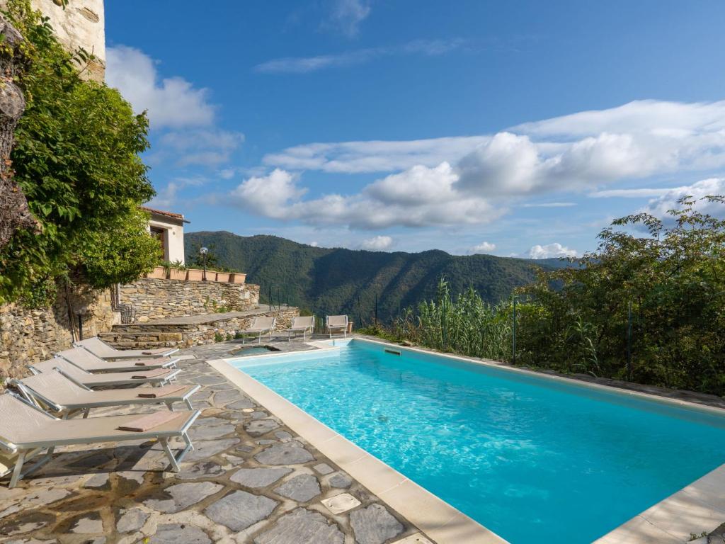 una piscina con tumbonas junto a una montaña en Apartment Il Loggiato - TVE170 by Interhome, en Tavole