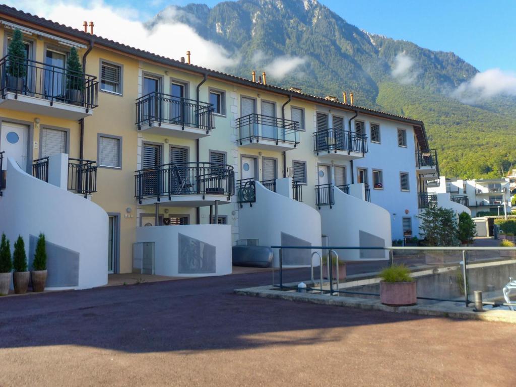 a building with balconies and a mountain in the background at Apartment Bougainville C3-R by Interhome in Bouveret