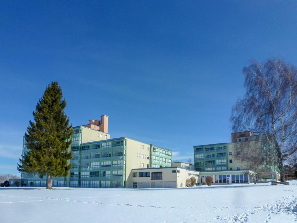 a building in the snow with a tree in the foreground at Apartment F 112 in Dittishausen