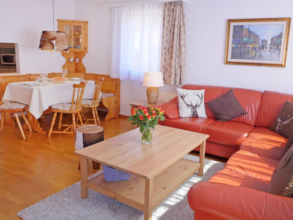 een woonkamer met een rode bank en een tafel bij Apartment Chesa Sur Val 22 by Interhome in St. Moritz