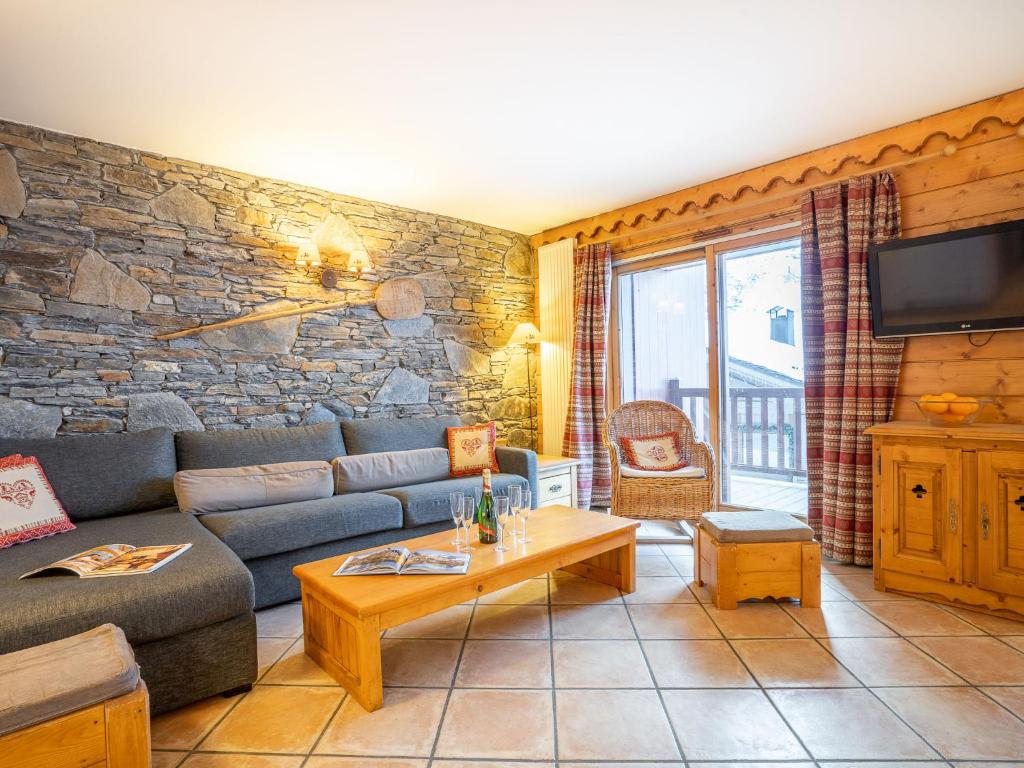 a living room with a couch and a tv at Apartment Ecrin des Neiges - Val Claret-1 by Interhome in Tignes