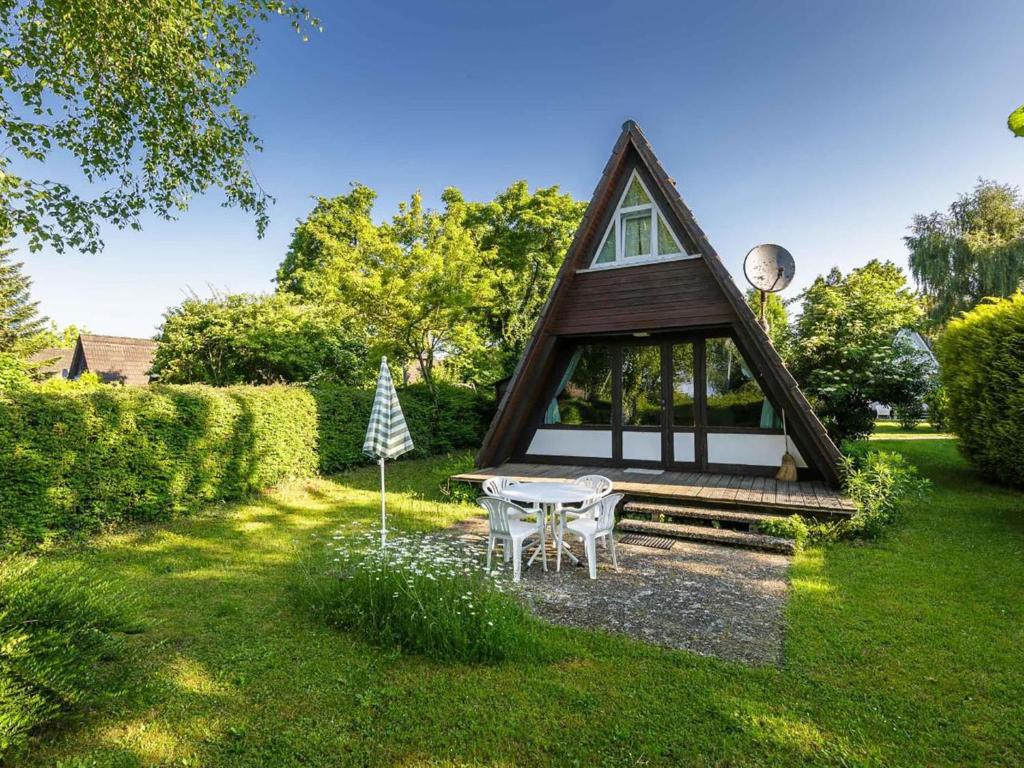 a small house with a table in a yard at Holiday Home Ferienwohnpark Immenstaad-3 by Interhome in Immenstaad am Bodensee