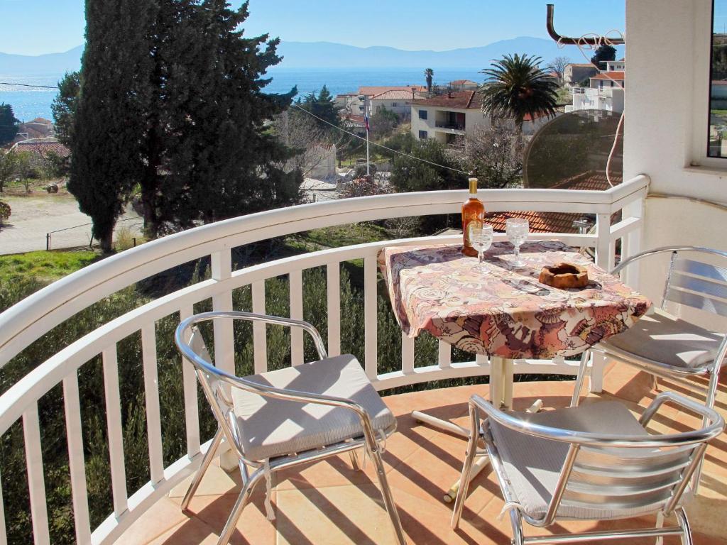 a table with a bottle of wine on a balcony at Apartment Rudez-1 by Interhome in Gradac