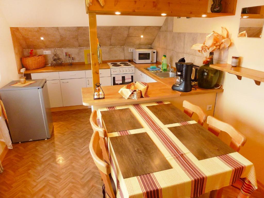 uma cozinha com uma mesa com cadeiras e um fogão em Apartment Allmendgasse by Interhome em Schelingen