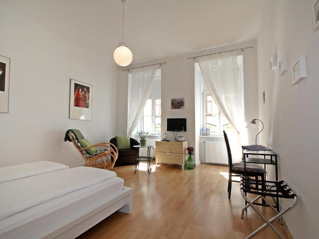 1 dormitorio con 1 cama y sala de estar con sillas en Apartment Am Margaretenplatz by Interhome, en Viena