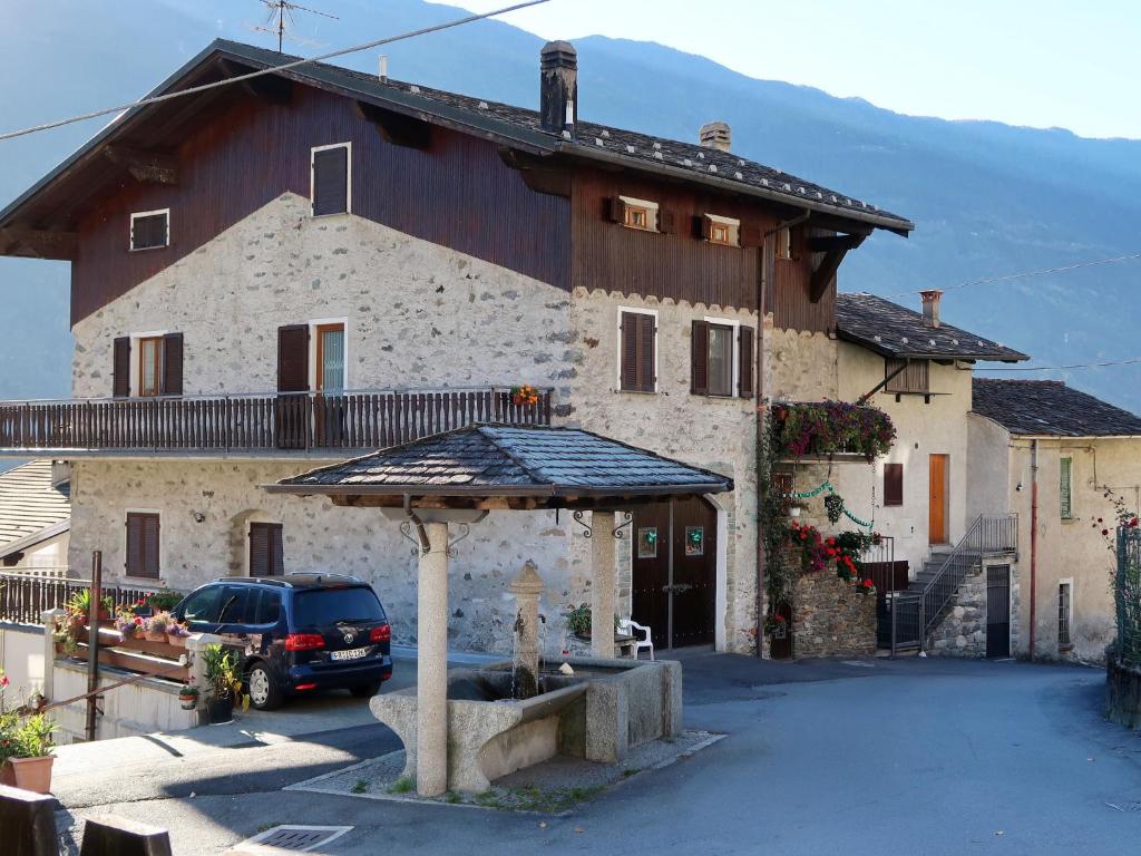 una casa grande con un coche aparcado delante de ella en Apartment Mariella by Interhome, en Mazzo di Valtellina