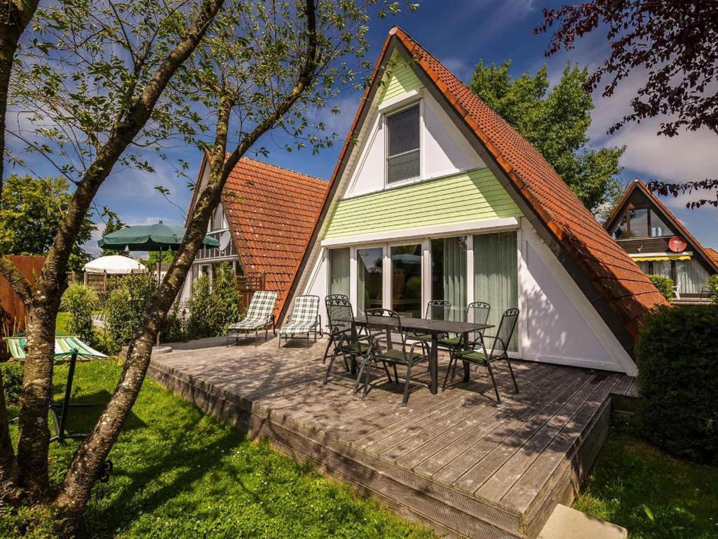 ein Haus mit einem Tisch und Stühlen auf einer Terrasse in der Unterkunft Holiday Home Ferienwohnpark Immenstaad-1 by Interhome in Immenstaad am Bodensee