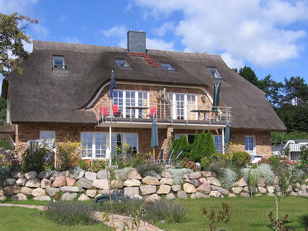 ein großes Haus mit einem Steinzaun davor in der Unterkunft Apartment Sonnenkliff-1 by Interhome in Groß Zicker