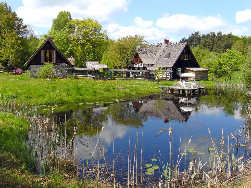 a house with a pond in front of it at Holiday Home Sianowska Huta by Interhome in Prokowo