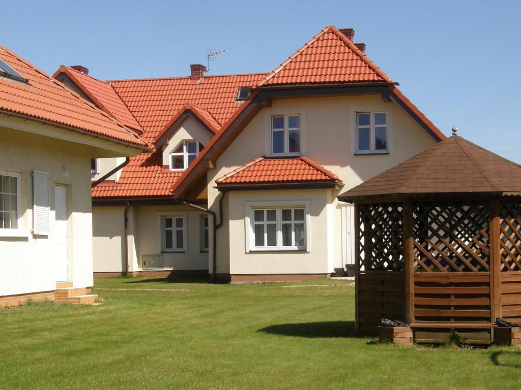 a house with a gazebo in the yard at Holiday Home Mały dworek by Interhome in Łeba
