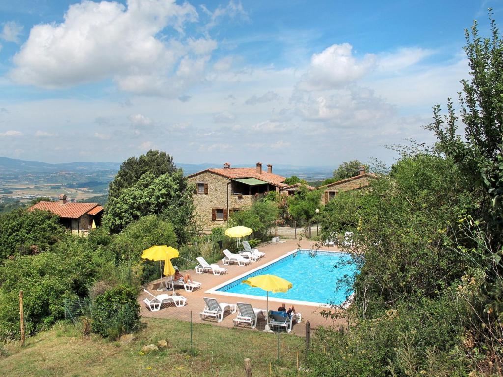 - une piscine avec des chaises et des parasols en face d'une maison dans l'établissement Holiday Home Paradiso Selvaggio-2 by Interhome, à Paciano