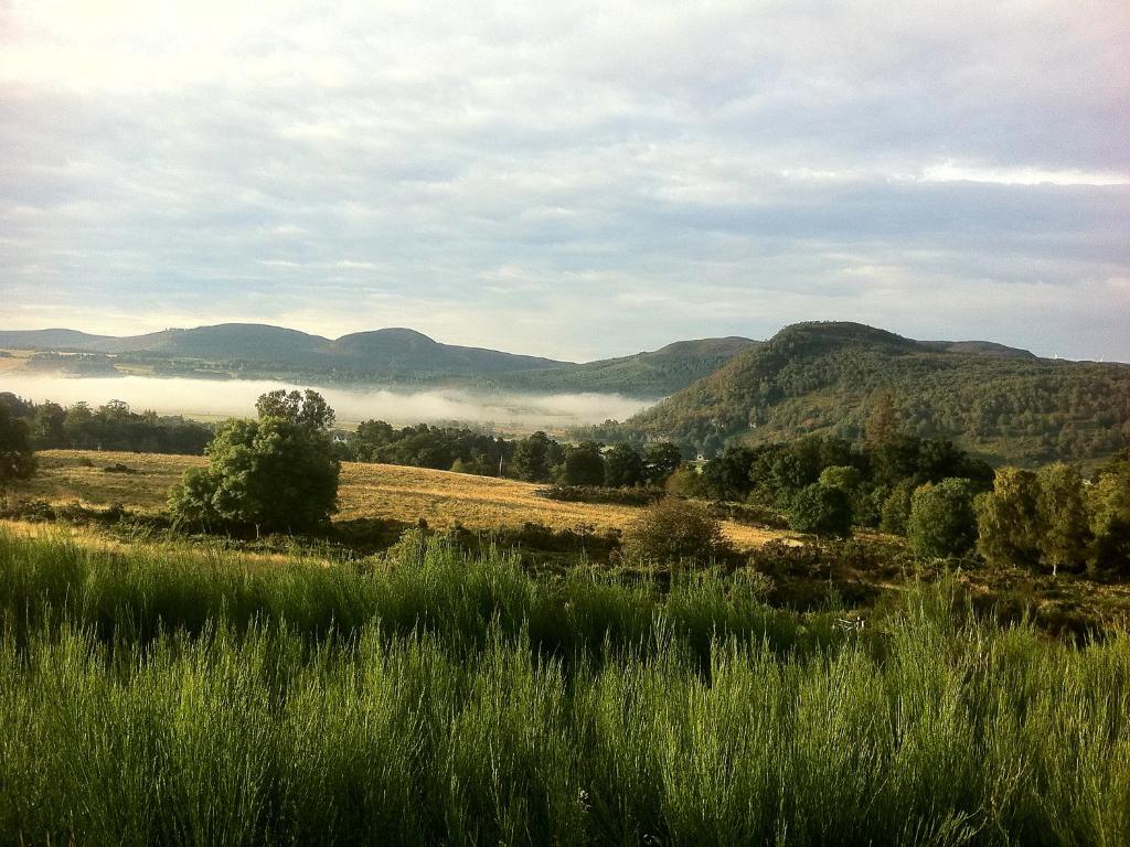 a view of a field with mountains in the background at Holiday Home Lochness by Interhome in Contin