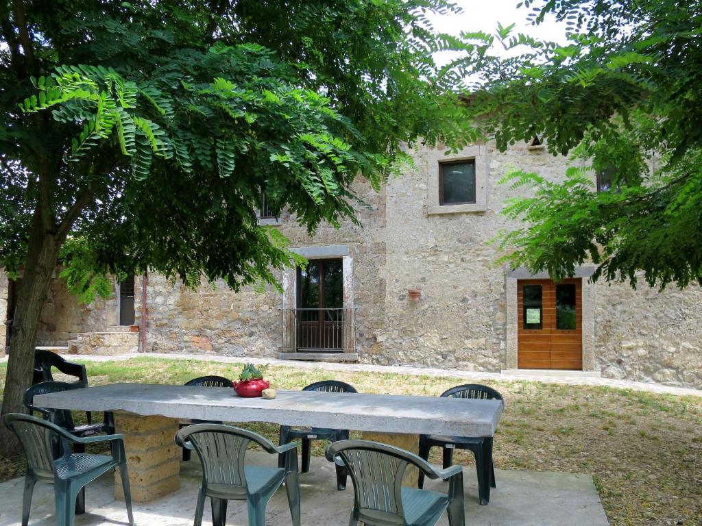 a table and chairs in front of a stone building at Holiday Home Pasqualino by Interhome in Bagnoregio