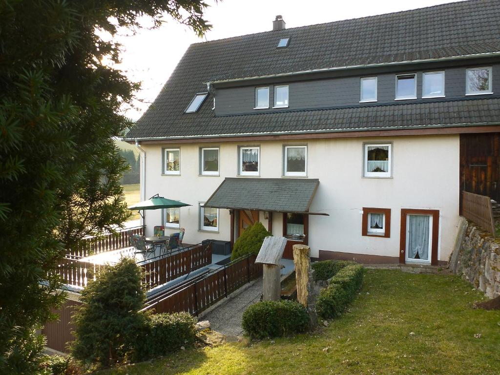 ein großes weißes Haus mit einer Veranda und einer Terrasse in der Unterkunft Apartment Schuler by Interhome in Unterkirnach