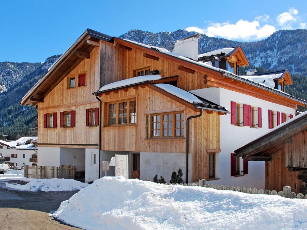 a house in the snow with mountains in the background at Holiday Home Mantel by Interhome in Mazzin