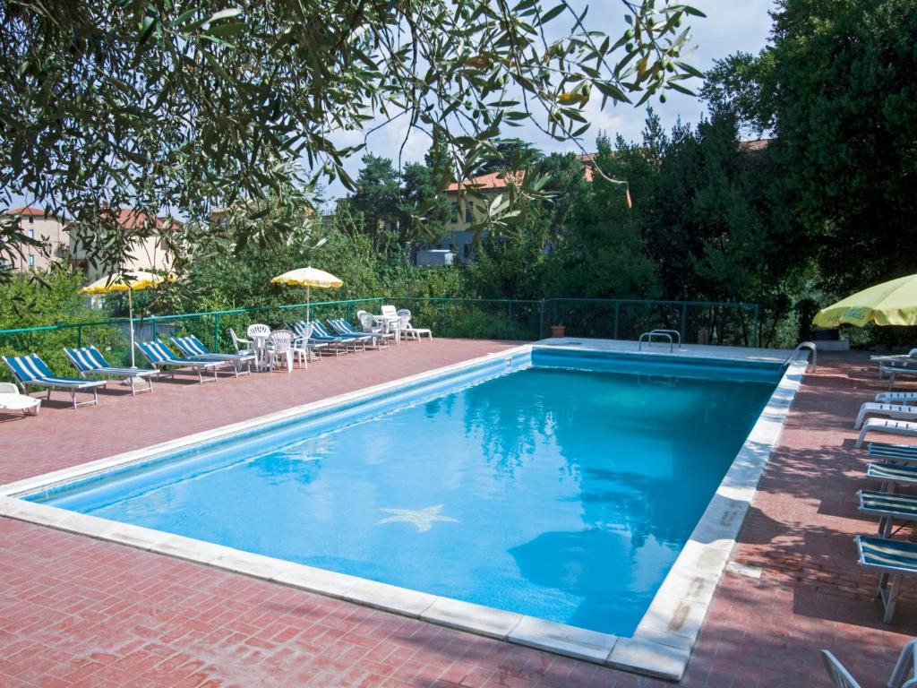 een zwembad met stoelen en parasols op een patio bij Apartment Vacanza L'Olivo by Interhome in Paciano