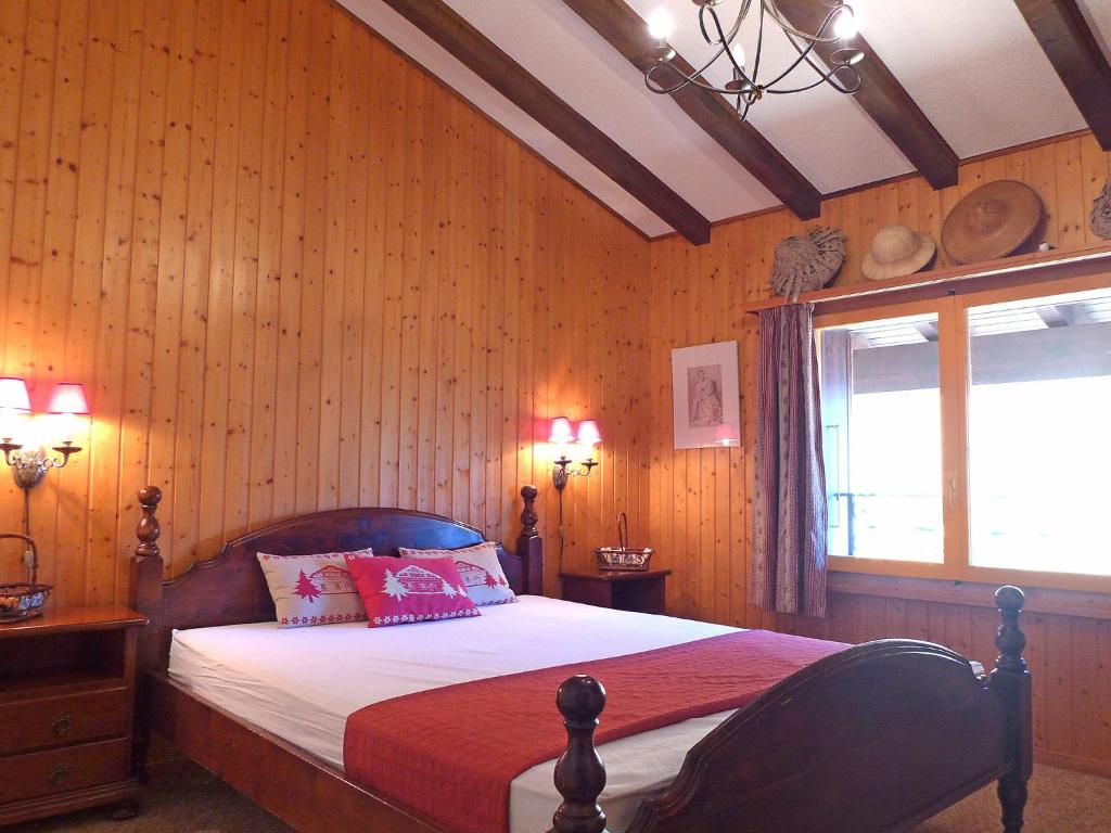 um quarto com uma cama com paredes de madeira e uma janela em Apartment Parc B 431 by Interhome em Champex