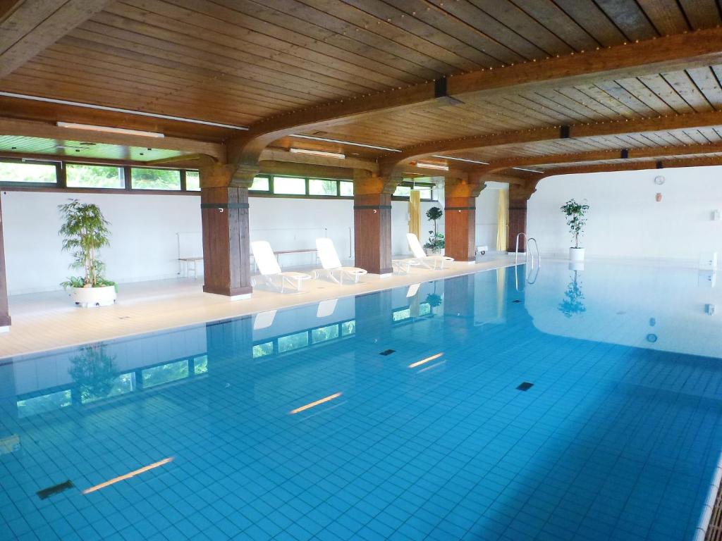 ein großer Pool mit Stühlen in einem Gebäude in der Unterkunft Apartment Terrassenpark-4 by Interhome in Obertal