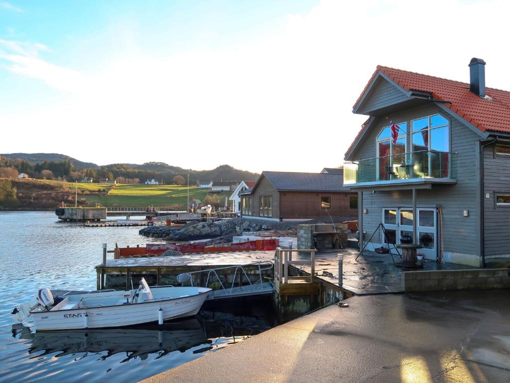 ein Boot, das an einem Dock neben einem Haus parkt in der Unterkunft Holiday Home Jektastøo - FJH660 by Interhome in Nordhuglo