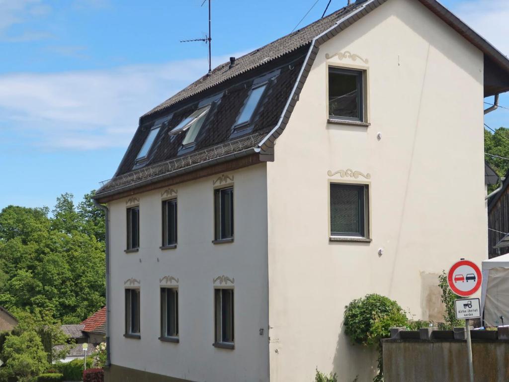 a white house with a black roof at Apartment Nürburgblick by Interhome in Quiddelbach